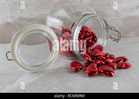 Jar von roten Herzen auf der Seite. Von der Seite. Tan Hintergrund. Stockfoto