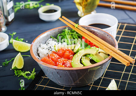 Hawaiian Lachs Fisch poke Schüssel mit Reis, Avocado, Paprika, Sesam und Kalk. Buddha Schüssel. Diät essen. Stockfoto