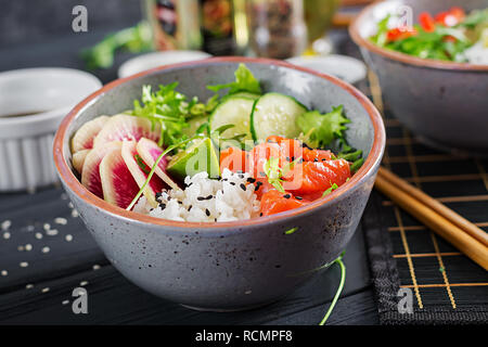Hawaiian Lachs Fisch poke Schüssel mit Reis, Gurken, Rettich, Sesamsamen und Kalk. Buddha Schüssel. Diät essen. Stockfoto