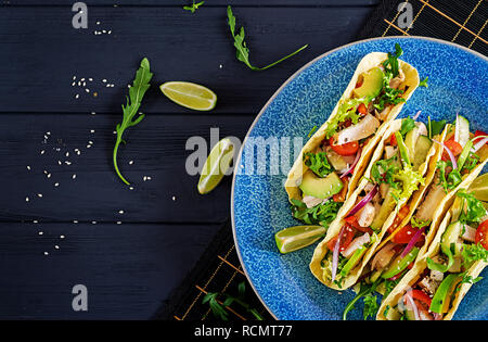 Mexikanische Tacos mit Hähnchenfleisch, Avocado, Tomate, Gurke und Zwiebeln. Gesunde Tortilla. Wickeln Sie essen. Taco. Ansicht von oben Stockfoto