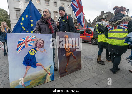 London, Großbritannien. 15. Januar 2019. Politischer Künstler Kaya Mar hält seine paintingsof Mai und Corbyn. Gruppen gegen die EU verlassen, einschließlich sodem, Bewegung für Gerechtigkeit und in der Vorhölle und Brexiteers Verlassen bedeutet verlassen und andere Protest gegenüber dem Parlament als Theresa's kann Brexit umzugehen, wurde diskutiert. Während die beiden Gruppen vor allem fern, eine kleine Gruppe, einige in gelben Jacken zu schreien, Beleidigungen an Pro-EU-Aktivisten kamen, während die Polizei versucht, die beiden Gruppen zu trennen. Credit: Peter Marschall/Alamy leben Nachrichten Stockfoto