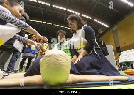 Tokio, Japan. 16 Jan, 2019. Ausländische Bevölkerung die Teilnahme an einem Erste Hilfe Kurs während der Katastrophenvorsorge Bohrer für ausländische Einwohner im GJ 2018 Komazawa Olympic Park Allgemeine Sportplatz. Über 263 Teilnehmer (einschließlich Tokyo ausländische Bewohner und der Mitglieder von Botschaften und internationalen Organisationen) wurden angewiesen, wie sie sich im Falle von Erdbeben Katastrophe zu schützen, indem die Tokyo Feuerwehr mit der Unterstützung von freiwilligen Dolmetschern in Englisch, Chinesisch, Spanisch und Französisch. Die Teilnehmer lernten, Brust Kompression, Vorschriften des Tierheim leben und erfahren. Stockfoto