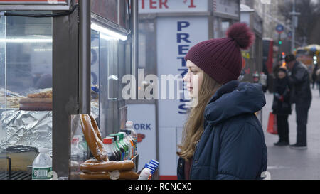 Junge Frau kauft ein Hot Dog in den Straßen von New York Stockfoto