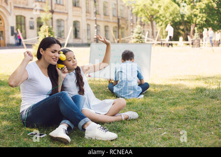 Kinder und Lehrer genießen in Park Stockfoto