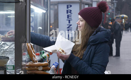 Junge Frau kauft ein Hot Dog in den Straßen von New York Stockfoto