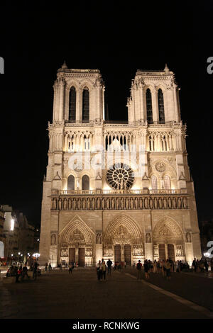 Eindrucksvolle Fassade der Kathedrale Notre Dame in Paris in Frankreich durch die Nacht mit einigen Touristen Stockfoto