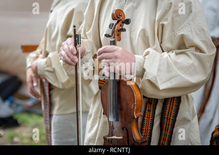 Riga. Lettland. Ein Mann in Tracht hält eine Geige in der Hand. Stockfoto