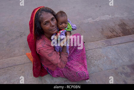 Weibliche Bettler mit Baby am Straßenrand. Stockfoto