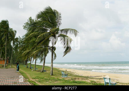 Strand und Meer mit glückliches Paar stehend auf einem Strand im Hintergrund. Zwei Liebende im Urlaub in idyllischer Natur Szene teilen positive Gefühl Stockfoto