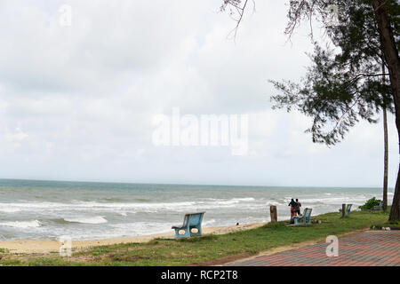 Strand und Meer mit glückliches Paar stehend auf einem Strand im Hintergrund. Zwei Liebende im Urlaub in idyllischer Natur Szene teilen positive Gefühl Stockfoto