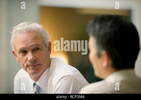 Reifen erwachsenen Geschäftsmann mit Kollegen im Büro. Stockfoto