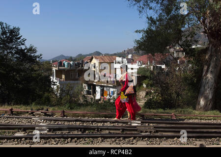 Shimla Eisenbahn, Solan Station, eine Frau im roten Kleid zu Fuß entlang der Schienen' Stockfoto