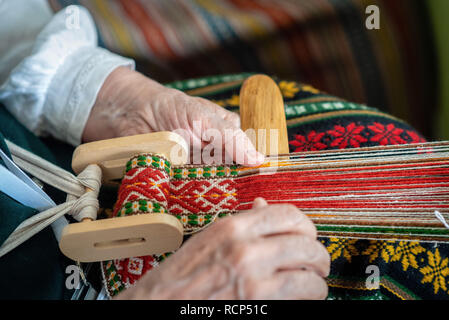 Frau am Webstuhl. Traditionelle ethnische Handwerk der Ostsee. - Bild Stockfoto