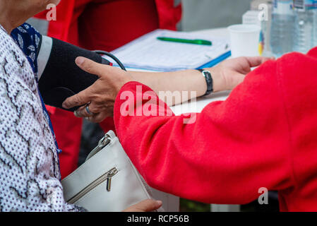 Der Arzt prüft den Blutdruck auf der alten Frau. Stockfoto