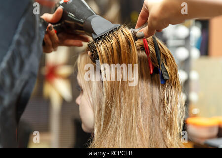 Professionelle Friseur färben Haare ihrer Kunden im Salon. Haircutter trockene Haare mit Fön. Selektive konzentrieren. Stockfoto