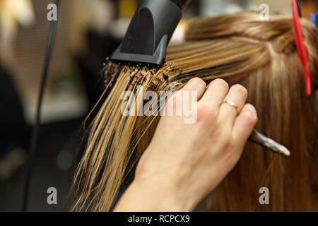 Professionelle Friseur färben Haare ihrer Kunden im Salon. Haircutter trockene Haare mit Fön. Selektive konzentrieren. Stockfoto