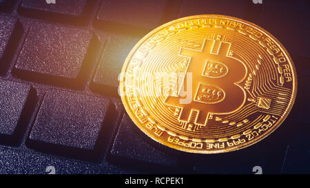 Bitcoin auf Computer Tastatur im Hintergrund, Symbol der elektronischen virtuelles Geld und Bergbau cryptocurrency Konzept. Münze crypto Währung bitcoin liegt auf Stockfoto