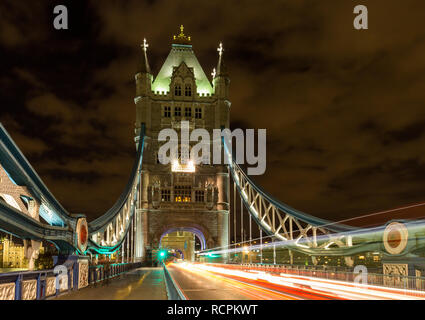 Tower Bridge in London, Vereinigtes Königreich in der Nacht mit sich bewegenden roten Doppeldecker-Bus leichte Spuren zu hinterlassen Stockfoto