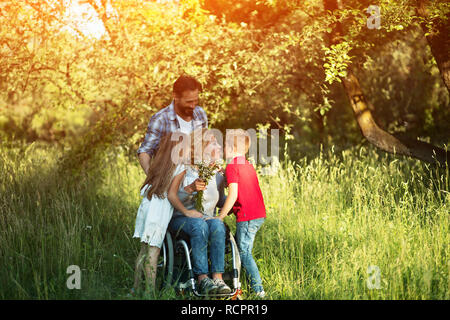 Porträt der jungen Frau im Rollstuhl küssen ihr Sohn Stockfoto