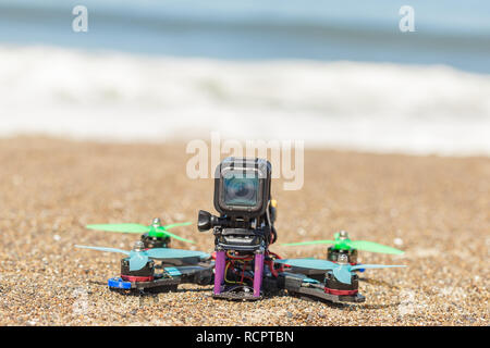 Kleine Quadrocopter, Copter, Drone mit montierten Action Kamera steht auf dem Meer Strand bereit zu fliegen Stockfoto