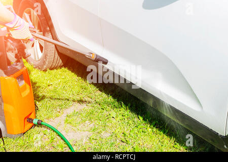 Manuelle Autowäsche mit Wasser unter Druck in car wash außerhalb. Sommer Auto waschen. Reinigung Auto mit hohem Druck Wasser. Von Autoteilen. Hand Scheibe. Stockfoto