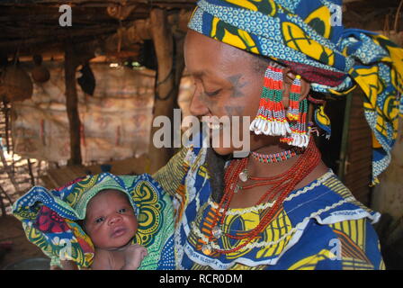 Ein junger Fulbe Mutter mit traditionellen Narben und Schmuck mit Ihrem neugeborenen Tochter im Niger, Afrika. Stockfoto