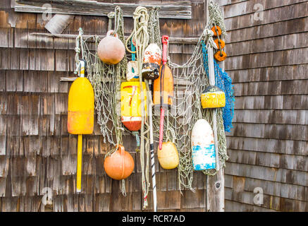 Bunte Hummer Bojen und Fischernetz hängen an der Wand eines verwitterten Angeln shack in Massachusetts Stockfoto