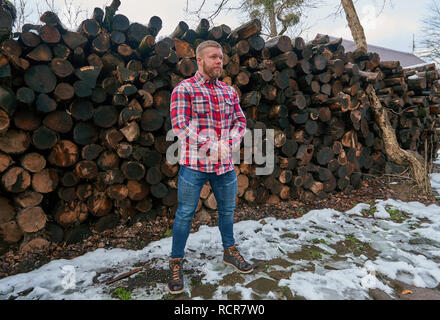 Mann in einem Hemd in der Nähe der Protokolle Stockfoto