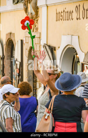 Prag, tschechische Republik - Juli 2018: Tour Guide in Prag winken und halten eine bunte Blume als Flag die Aufmerksamkeit der Menschen anzuziehen Stockfoto