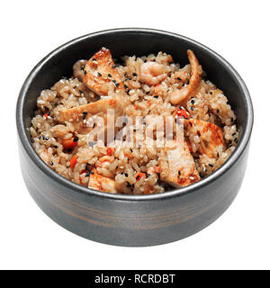 Reis mit gebratenes Huhn, Garnelen, Gemüse und Sesam im schwarzen Schüssel. Auf weissem Hintergrund. Leckeres Restaurant Dish. Stockfoto