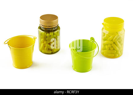 Bunte Flaschen mit Pillen und zwei Eimer. Auf weissem Hintergrund. Stockfoto