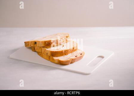 Frisch gebackenes Brot auf Holz Schneidebrett auf weißem Hintergrund Stockfoto