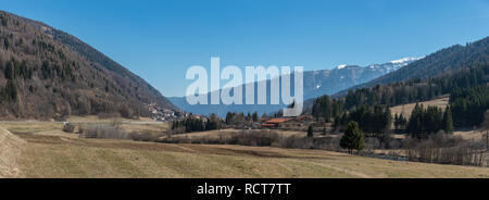 Panoramablick auf Trentino-Alto Adige, Südtirol, Trient, Val di Sole, Italien im Frühjahr. Schneebedeckte Berge alpine Berggipfel, Hügel und Bäume. Stockfoto