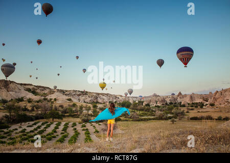 Junge Mädchen beobachten ein Himmel voller Heißluftballons Stockfoto