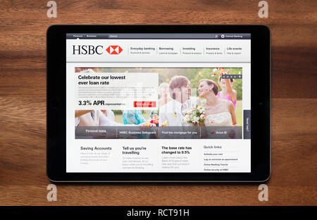 Die Website von HSBC Bank gesehen auf einem iPad Tablet, der ruht auf einem Holztisch (nur redaktionelle Nutzung). Stockfoto