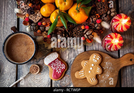 Weihnachten hausgemachte Lebkuchen cookies, heiße Schokolade und Kerzen auf hölzernen Tisch Stockfoto