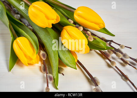 Schöne Ostern Dekoration der gelbe Tulpen und Palmkätzchen auf einem weißen Tisch Stockfoto