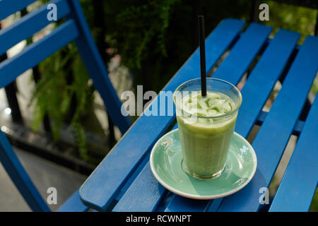 Iced Matcha Latte auf dem blauen Hintergrund Stockfoto