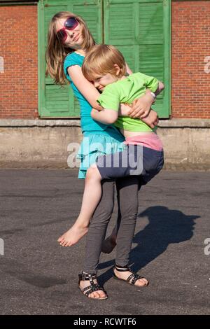 Mädchen tragen ihr jüngeren Bruder Stockfoto