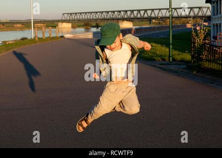 Kleinen Jungen springen mit seinem Schatten, Hohnstorf, Niedersachsen Stockfoto