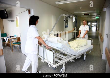 Krankenschwestern Transport eines Patienten in ein Bett innerhalb der Station eines Krankenhauses Stockfoto