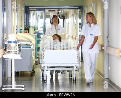 Krankenschwestern Transport eines Patienten in ein Bett innerhalb der Station eines Krankenhauses Stockfoto