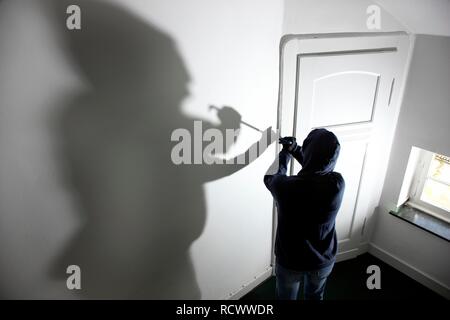 Einbruch, Einbrecher auf einer Treppe von einem Wohnhaus im Laufe des Tages Stockfoto