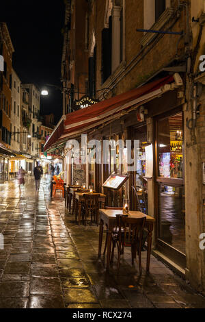 Venedig, Italien, 19. März 2018: Outdoor Cafe an der Gasse in Venedig bei Nacht Stockfoto