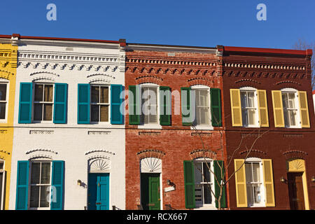 Hell gestrichenen gemauerte Häuser auf der Straße von Washington DC, USA. Bunte Häuser/ unter einem blauen Himmel nach den jüngsten Schneesturm. Stockfoto