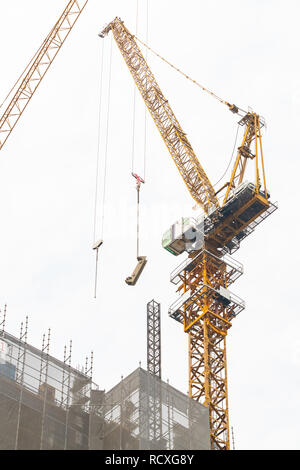 Baukräne am Arbeitsplatz ein hohes Gebäude in Bangkok zu konstruieren Stockfoto