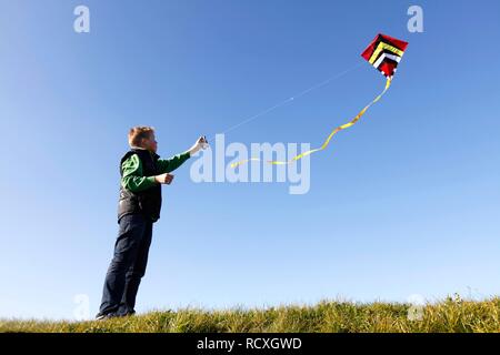 Junge, 12, Flying a Kite Stockfoto