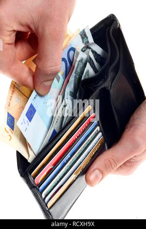 Hände, die Geldbörse mit verschiedenen Kreditkarten, Bankkarten, Euro Stockfoto