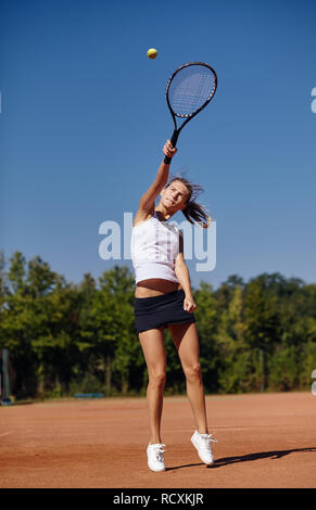 Ein Mädchen spielen Tennis auf dem Tennisplatz an einem sonnigen Tag Stockfoto