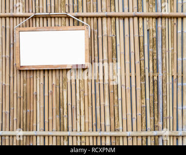 Blank white label als Holz- grenze hängen an Bambus Wand Hintergrund Stockfoto